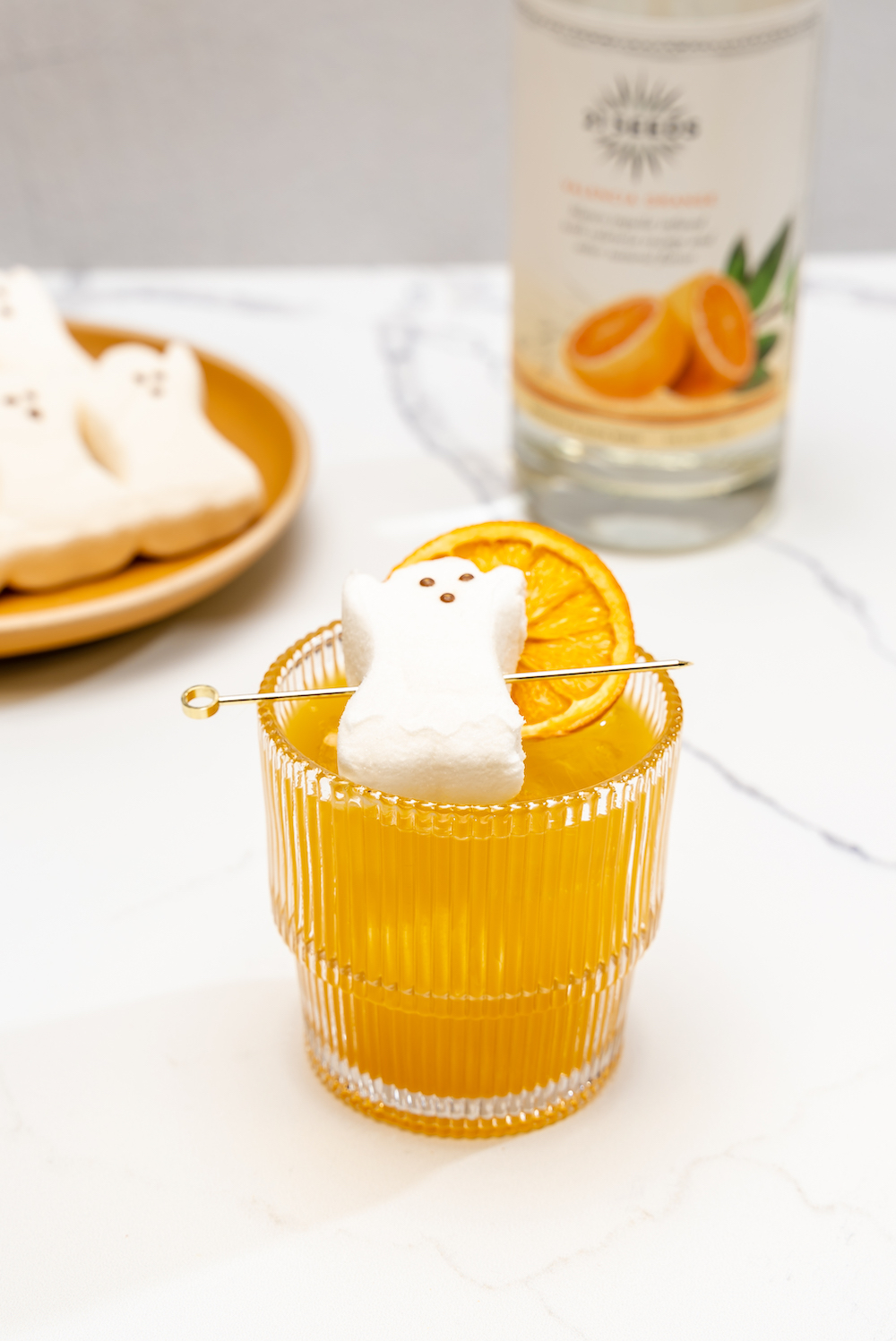 Pumpkin Pie Punch cocktail with marshmallows and orange slices, a citrusy drink with a touch of sweetness.